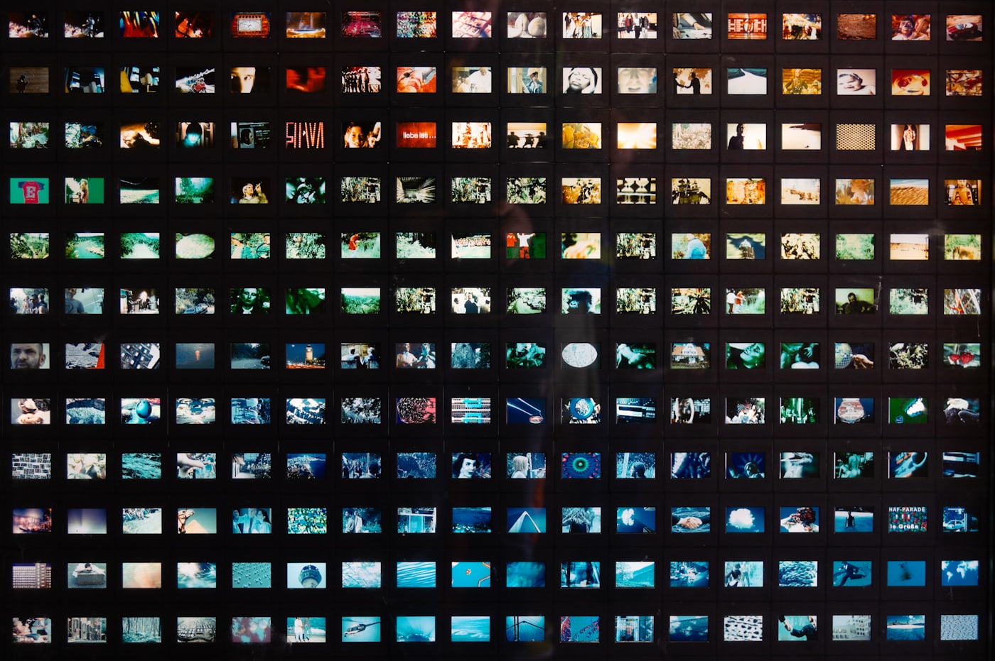 A wall of small printed photographs forming a thumbnail grid.